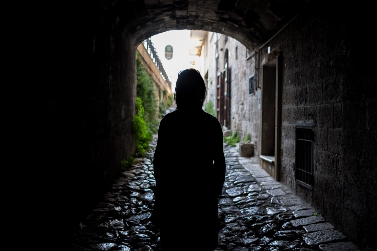 Lonley person in narrow , dark corridor