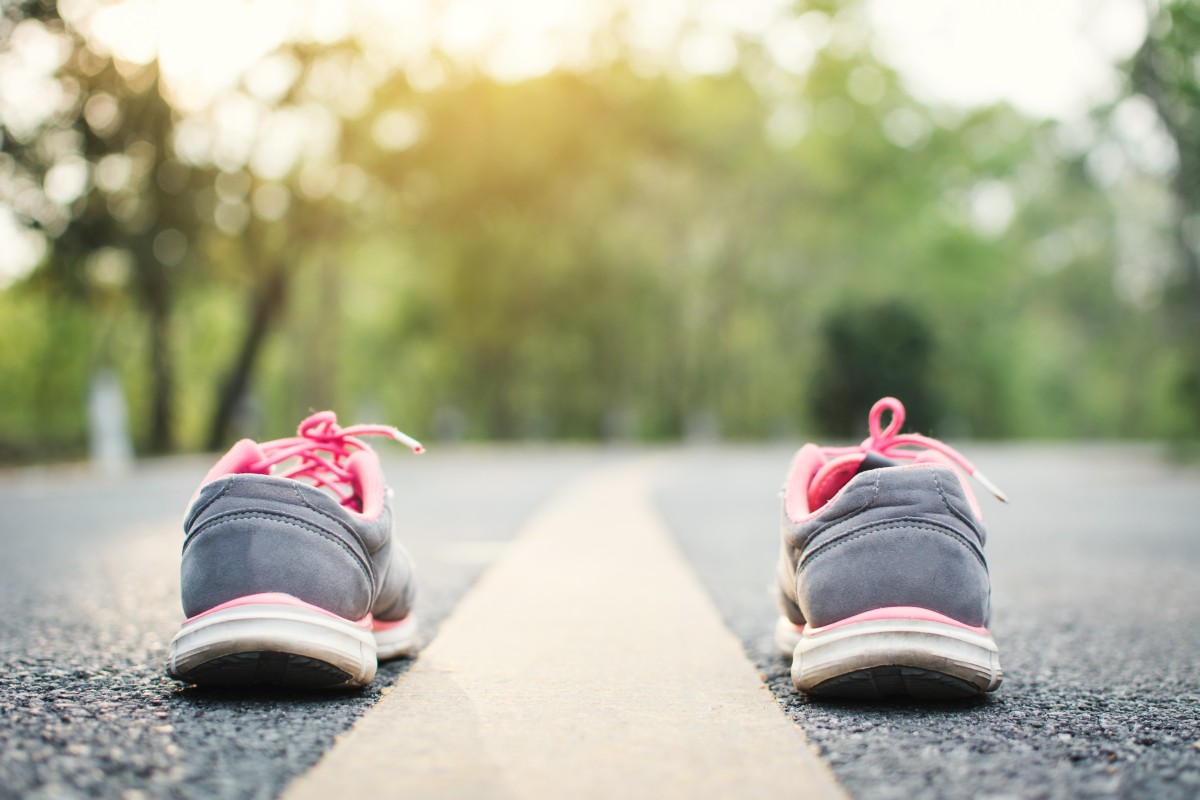 empty training shoes next to a road centre line, ready for the journey